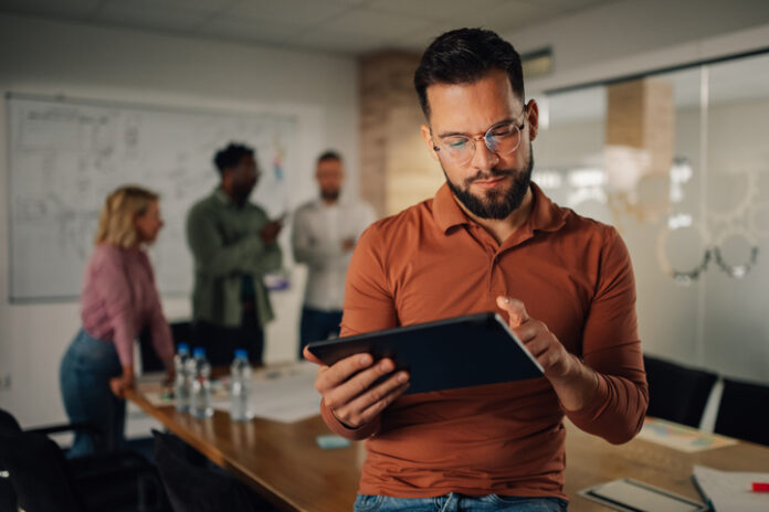 Focused businessman using digital tablet during office meeting founder of business working using a tablet