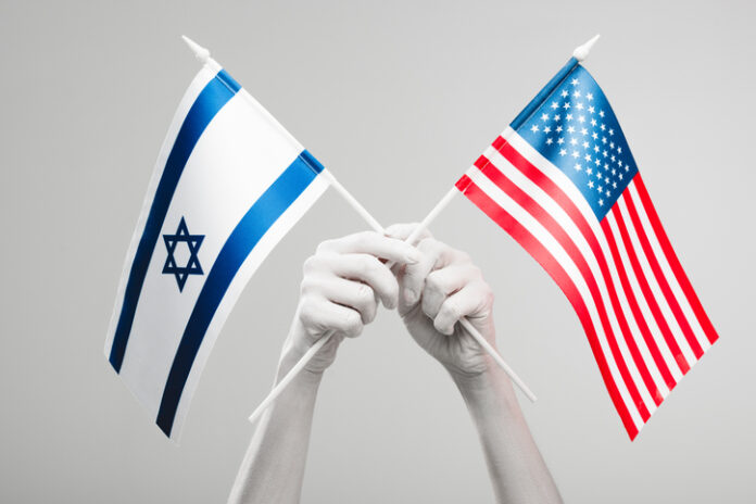cropped view of female hands painted in white holding crossed american and israel flags isolated on grey Bipartisan Consensus on US-Israel