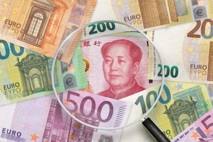 Chinese yuan and Euros banknotes. EU and China trade war . View through magnifying glass Renminbi