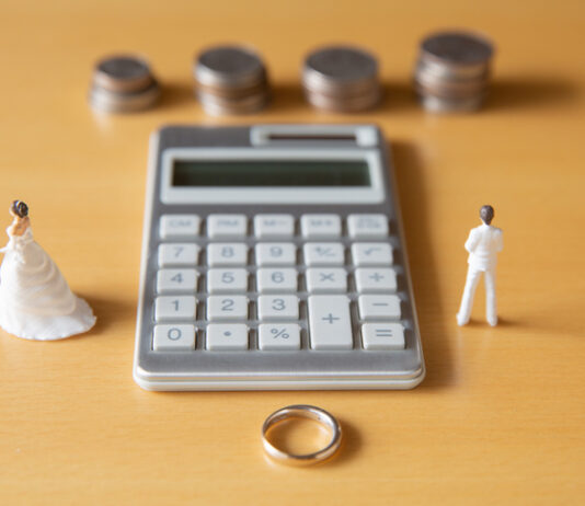 The Retirement Asset Most Divorcing Couples Undervalue Couple in troubles in connection with divorce, marriage and family. Retirement Asset. Concept of couple's money troubles with calculator and ring.