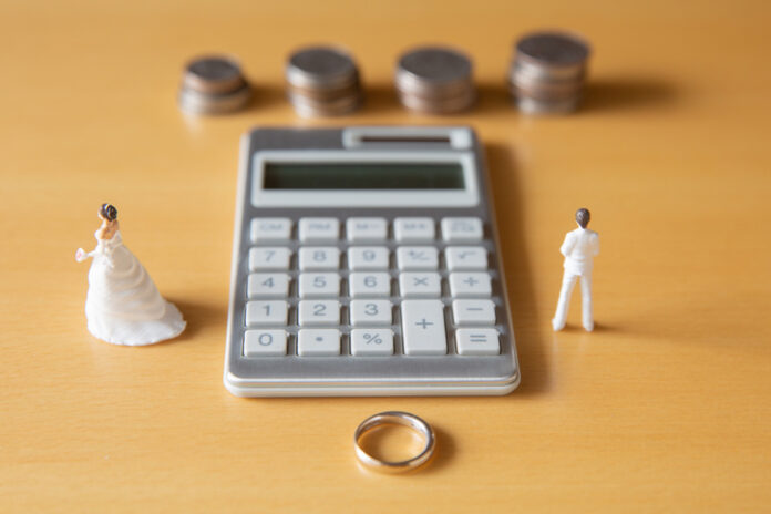 Couple in troubles in connection with divorce, marriage and family. Retirement Asset. Concept of couple's money troubles with calculator and ring.