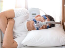 Sleep Apnea Treatment Options - Man in bed wearing CPAP mask
