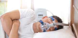 Sleep Apnea Treatment Options - Man in bed wearing CPAP mask