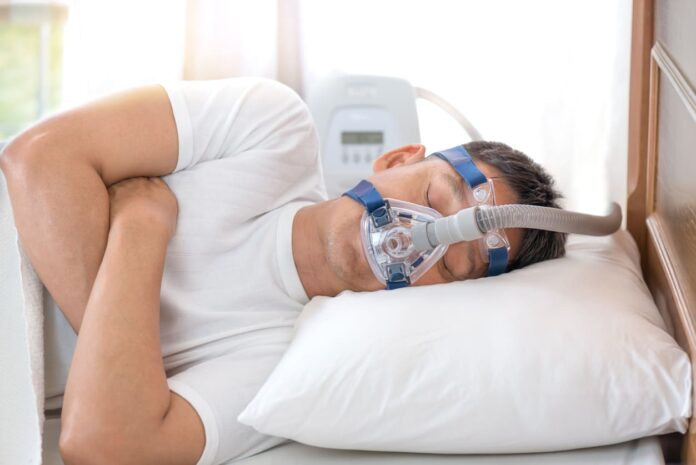 iStock-629586444 (1) Sleep Apnea Treatment Options - Man in bed wearing CPAP mask