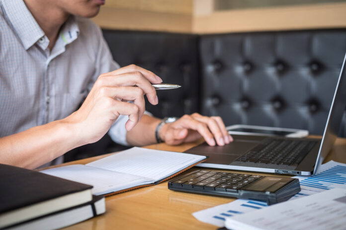 Businessman working investment project on laptop computer with report document and analyze, calculating financial data on graph documents, doing finance making statistics SIP Calculator