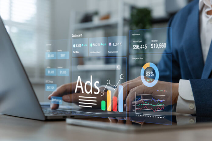 Businessman using laptop to monitor online advertising metrics through a digital dashboard. creator advertising
