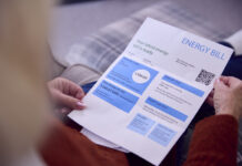 Strategies UK Businesses are Adopting to Lower Energy Bills Close Up Of Senior Woman At Home Looking At Energy Bill During Cost Of Living Energy Crisis