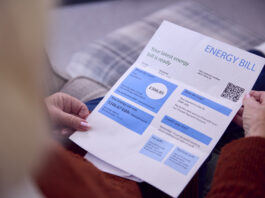 Strategies UK Businesses are Adopting to Lower Energy Bills Close Up Of Senior Woman At Home Looking At Energy Bill During Cost Of Living Energy Crisis