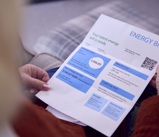 Strategies UK Businesses are Adopting to Lower Energy Bills Close Up Of Senior Woman At Home Looking At Energy Bill During Cost Of Living Energy Crisis