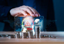 Business man using hand to protect a stack of coins with a red warning sign for risk management. Concept of business or financial risks. Africa’s Financing Gap concept