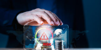Business man using hand to protect a stack of coins with a red warning sign for risk management. Concept of business or financial risks. Africa’s Financing Gap concept