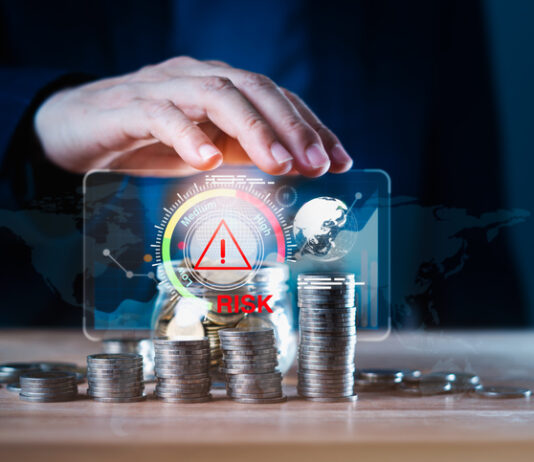 From Perceived Risk to Bankable Investment: Closing Africa’s Financing Gap Business man using hand to protect a stack of coins with a red warning sign for risk management. Concept of business or financial risks. Africa’s Financing Gap concept