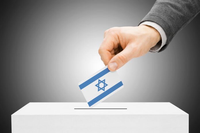 Male inserting flag into ballot box - Israel